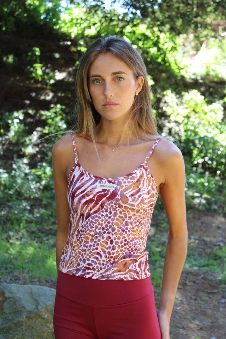 Top deportivo de tirantes finos Nora Wild con estampado animal print de cebra y leopardo en burdeos y teja – puesto en modelo | Etereo House