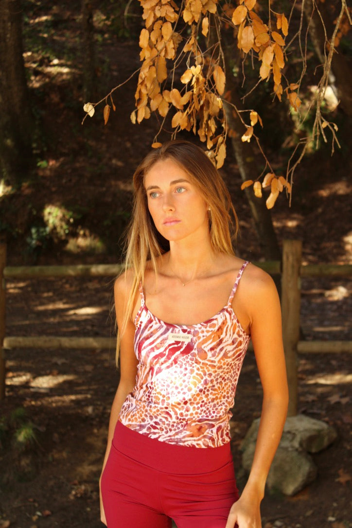 Top deportivo de tirantes finos Nora Wild con estampado animal print de cebra y leopardo en burdeos y teja – puesto en modelo | Etereo House